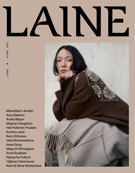 LAINE magazine cover, Autumn 2026 issue, featuring a model wearing a brown knit sweater with white geometric embroidery and a beige fringed scarf, set against a beige background with the brand name LAINE in large black letters.