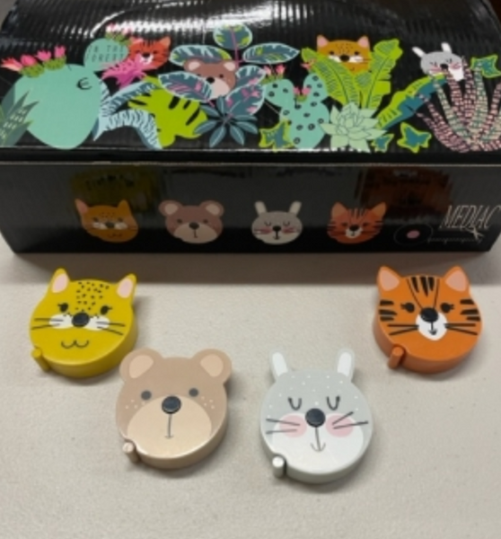 Four tape measures each with a different face - cat, bear, bunny and tiger. A black box with the image of multi color plants and animals.