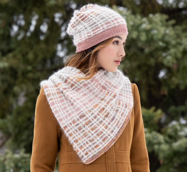 Woman wearing a knitted scarf and hat in a snowy outdoor setting