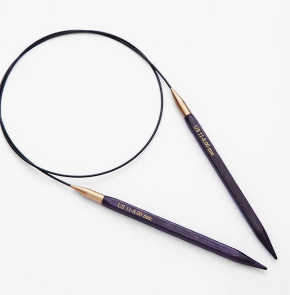 Pair of purple knitting needles with gold tips on a white background