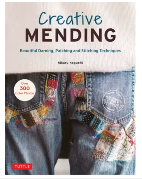 Front cover of the book 'Creative Mending' by hikaru noguchi, showing a close-up of blue denim jeans with colorful patchwork fabric details and the title text at the top.