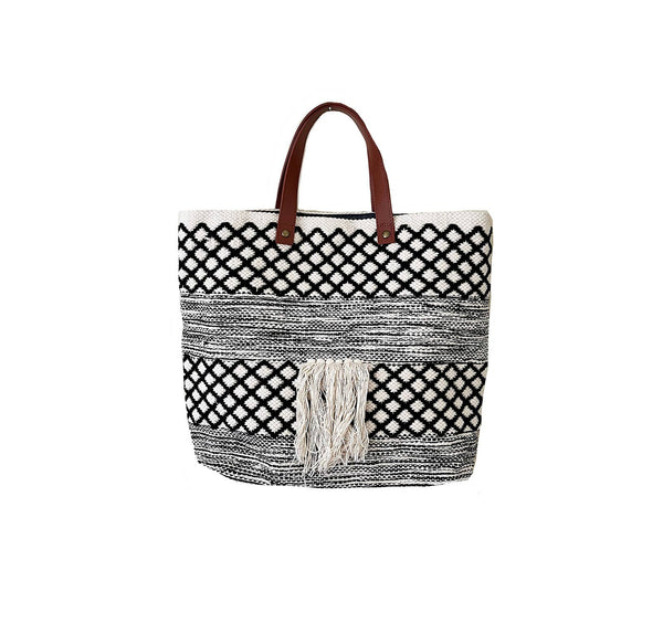 Black and ivory checkered tote bag with leather handles on a white background