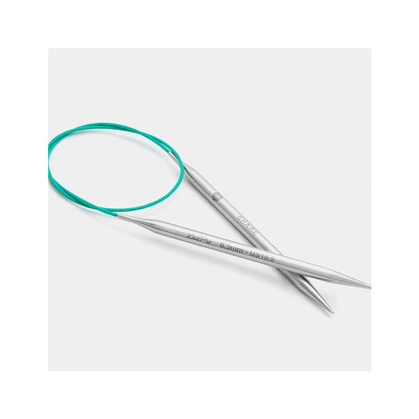 Silver knitting needles with a teal circular needle on a white background